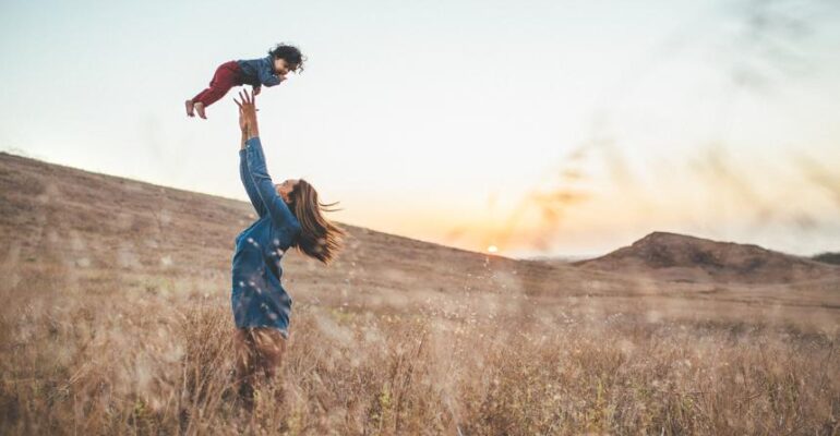 mãe jogando uma criança para cima